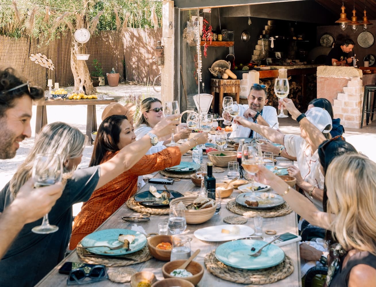Guests enjoying a Corfiot meal beneath the olive trees